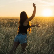 A demo photo of DET "Speak about the Photo" questions: a young woman standing in a field